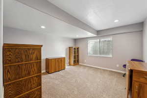 Interior space featuring a textured ceiling, recessed lighting, baseboards, and light carpet