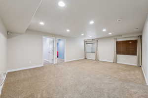 Below grade area with recessed lighting, baseboards, and light carpet