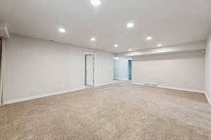 Spare room with visible vents, recessed lighting, and light colored carpet