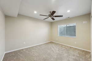 Carpeted empty room featuring recessed lighting, visible vents, baseboards, and a ceiling fan