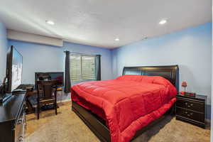 Carpeted bedroom with visible vents, recessed lighting, a textured ceiling, and baseboards