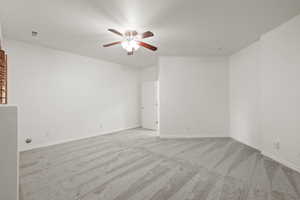 Spare room featuring a ceiling fan and carpet