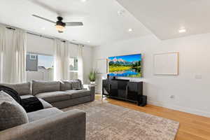 Living room featuring light wood-style flooring, recessed lighting, baseboards, and a textured ceiling