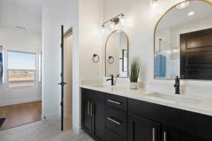 Bathroom with double vanity, visible vents, marble finish floor, and a sink