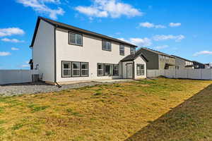 Rear view of house featuring central AC unit, a yard, a fenced backyard, and an outdoor structure