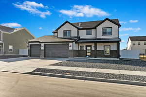 View of front of property featuring a porch, fence, concrete driveway, an attached garage, and brick siding