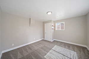 Carpeted empty room with baseboards