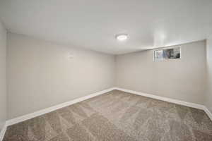 Basement featuring baseboards and carpet floors