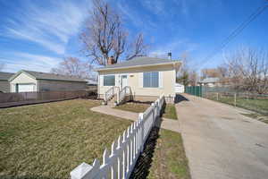 Bungalow-style home with a chimney, a front yard, and fence