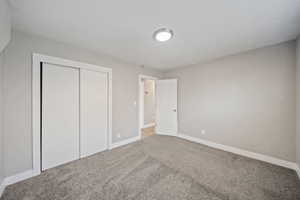 Unfurnished bedroom with carpet flooring, baseboards, and a closet