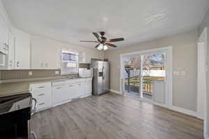 Kitchen featuring a sink, plenty of natural light, range with electric cooktop, and stainless steel fridge with ice dispenser