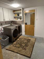 Laundry room with cabinet space, washing machine and clothes dryer, and baseboards