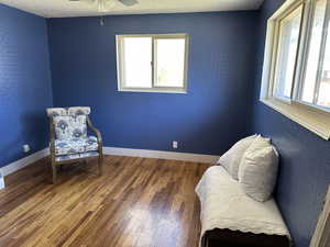 Sitting room featuring hardwood / wood-style flooring, a ceiling fan, and baseboards