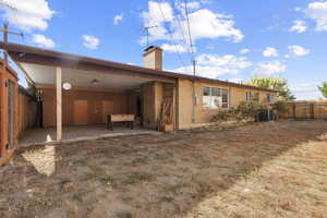 Rear view of property with a patio, a chimney, and brick siding