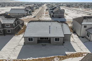 Snow covered property featuring a residential view and a patio area