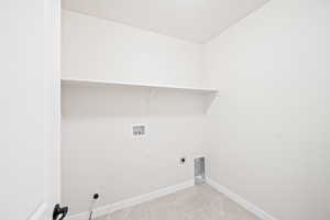 Washroom featuring hookup for a washing machine, light tile patterned floors, baseboards, hookup for an electric dryer, and laundry area