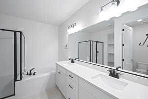 Full bathroom with a shower stall, a garden tub, double vanity, and a sink