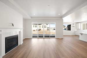 Unfurnished living room with recessed lighting, light wood-style flooring, a tile fireplace, and baseboards
