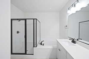 Full bath with a stall shower, vanity, and a garden tub