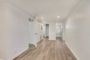 Hallway with visible vents, recessed lighting, light wood-type flooring, and baseboards