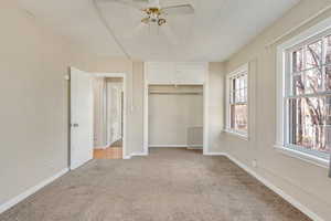 Unfurnished bedroom featuring baseboards, light carpet, a closet, and a ceiling fan