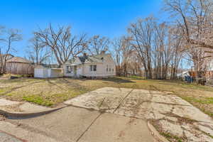 Back of property with fence, a chimney, a yard, an outbuilding, and an attached garage