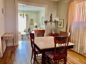 Dining area featuring baseboards, an inviting chandelier, and wood-type flooring