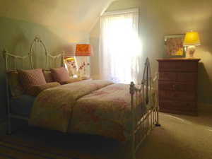 Carpeted bedroom featuring lofted ceiling