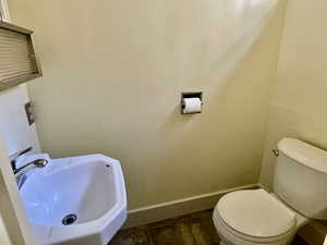 Half bathroom with baseboards, a sink, and toilet