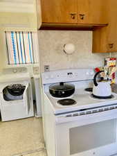 Clothes washing area featuring independent washer and dryer and laundry area