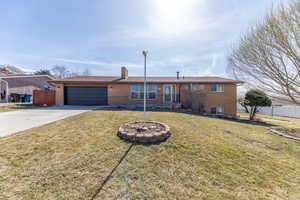 Single story home with a front yard, a garage, fence, and brick siding