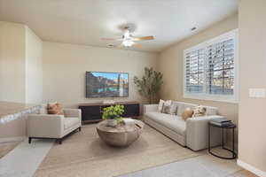 Tiled living room with baseboards, visible vents, a textured ceiling, and ceiling fan**Please note this is virtually staged**