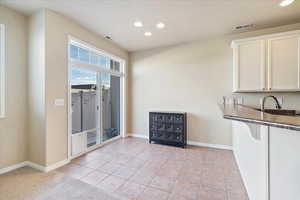 Interior space featuring light tile patterned floors, recessed lighting, visible vents, and baseboards