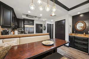 Dining space featuring visible vents, light wood-style flooring, recessed lighting, crown molding, and a raised ceiling