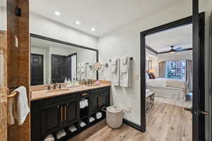 Bathroom featuring wood finished floors, ensuite bathroom, and a sink