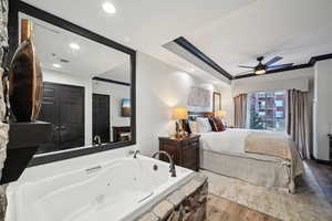 Bedroom with crown molding, wood finished floors, visible vents, and ceiling fan