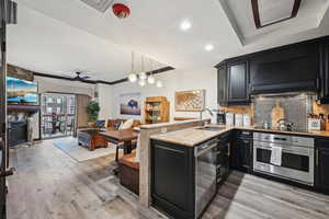 Kitchen with tasteful backsplash, oven, a peninsula, a fireplace, and a sink