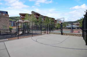 View of basketball court with community basketball court, playground community, and fence