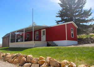 Manufactured / mobile home with entry steps, a front lawn, and a sunroom