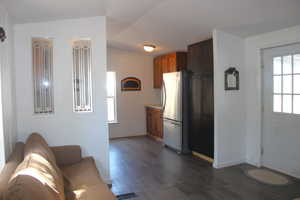 Kitchen featuring dark wood finished floors, light countertops, freestanding refrigerator, and baseboards