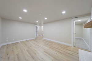Finished basement with recessed lighting, baseboards, visible vents, and light wood-type flooring