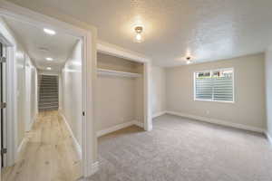 Unfurnished bedroom featuring a textured ceiling, baseboards, and a closet