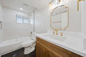 Bathroom featuring visible vents, washtub / shower combination, toilet, and vanity