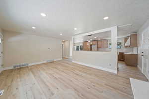 Unfurnished living room with visible vents, recessed lighting, and light wood-style flooring
