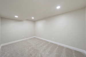 Unfurnished room featuring baseboards, recessed lighting, and light colored carpet
