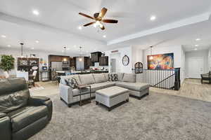 Living area featuring recessed lighting, a tray ceiling, light wood-style floors, and ceiling fan