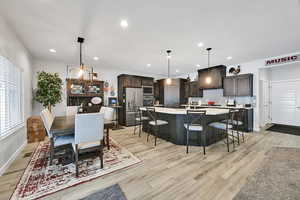 Kitchen featuring visible vents, stainless steel appliances, light countertops, dark brown cabinets, and tasteful backsplash