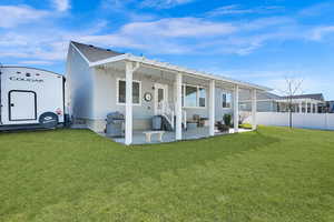 Rear view of house with a yard, a patio, a pergola, and fence