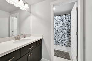 Bathroom with tile patterned floors, vanity, and shower / bath combination with curtain