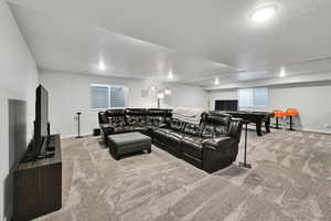 Carpeted living room with baseboards and a textured ceiling